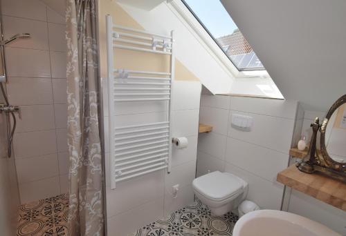 ein Bad mit einem WC und einem Dachfenster in der Unterkunft Schusterkate - [#96108] in Staberdorf