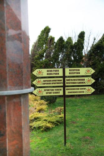 a street sign in the grass next to a building at S Club Resort Hotel Aqua Park and Spa in Belgrade