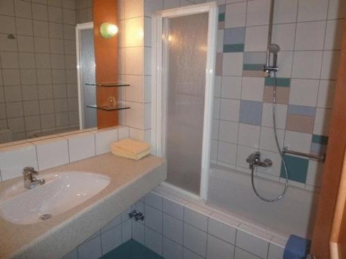 a bathroom with a shower and a sink and a tub at Hotel Marko in Nötsch