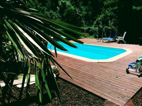 una piscina con terraza de madera y piscina en Auberge de Barnas, en Barnas