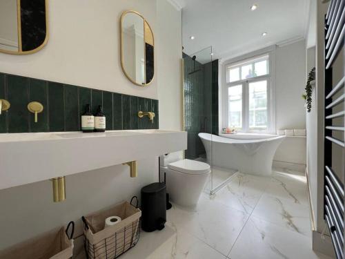een badkamer met een bad, een wastafel en een toilet bij STAY IN STYLE OPPOSITE WINDSOR CASTLE & free parking in Windsor