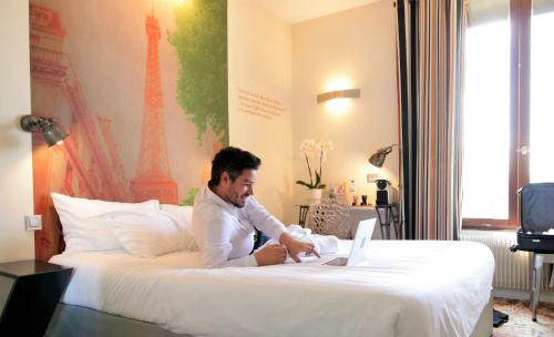 A bed or beds in a room at Hotel Alpha Paris Eiffel by Patrick Hayat