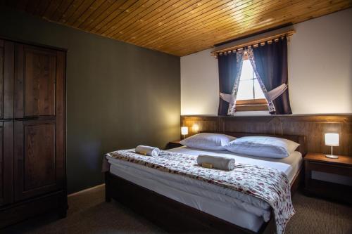 a bedroom with a large bed with a window at Rezort Drevenice Terchova in Terchová