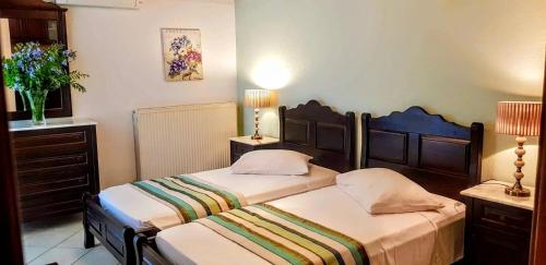 two beds in a room with two lamps and two beds sidx sidx sidx at Afrodite Hotel Apartments in Mirina