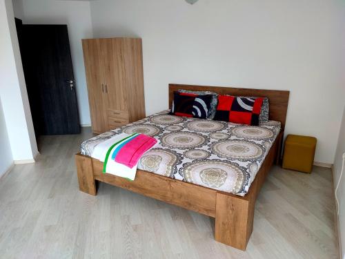 a bedroom with a wooden bed with colorful pillows at Apartments Alexandra in Opanets