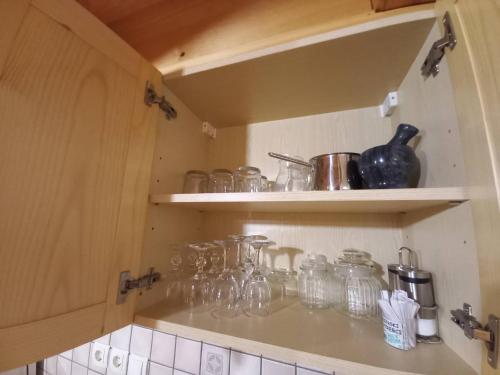 a kitchen with many glass jars on shelves at Vineyard Cottage Maleric with Pool Access in Dragatuš