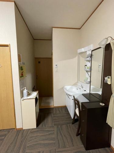 La salle de bains est pourvue d'un lavabo et d'un miroir. dans l'établissement すずめのお宿 セキレイの間 最大5名 Wagtail Room Maximum of 5 people, à Kotohira