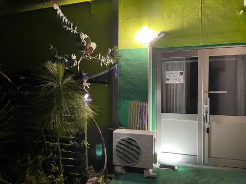 Cette chambre dispose d'un ventilateur et d'un mur vert. dans l'établissement すずめのお宿 セキレイの間 最大5名 Wagtail Room Maximum of 5 people, à Kotohira