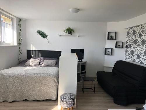 a bedroom with a bed and a couch at Le Clémenceau in Péronne