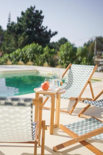 a table and a chair next to a pool at Birds of Paradise - Boutique Surf Lodge in Aljezur
