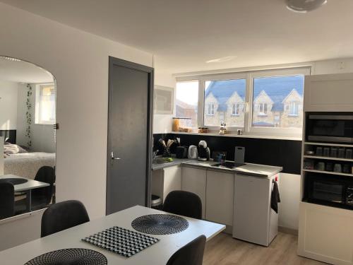 - une cuisine avec un évier et une table dans une chambre dans l'établissement Le Clémenceau, à Péronne