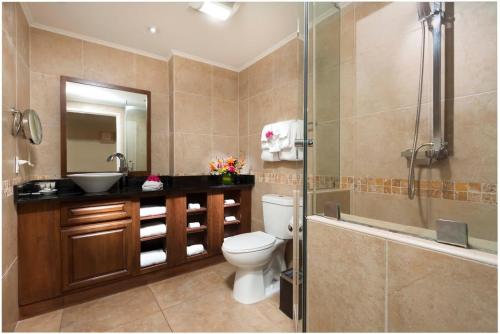 a bathroom with a toilet and a sink and a shower at Divi Aruba Phoenix Beach Resort in Palm-Eagle Beach