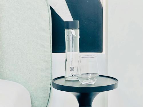 a bottle and a glass on a table at Canaryislandshost l Boya Suites in Playa Honda