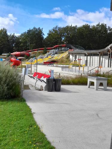 a park with a playground with slides and benches at Gîte Déco in Magnac-Laval