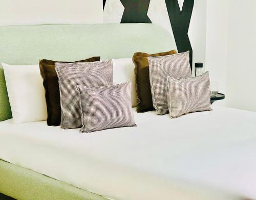 a white bed with four pillows on it at Canaryislandshost l Boya Suites in Playa Honda