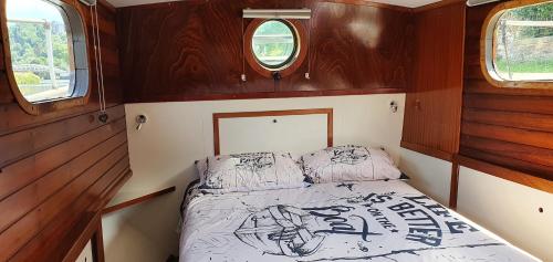 een slaapkamer met een bed achterin een boot bij Péniche Sir Lancelot in Thuin