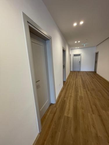 an empty hallway of an apartment with a wooden floor at Ladi Rooms in Tirana