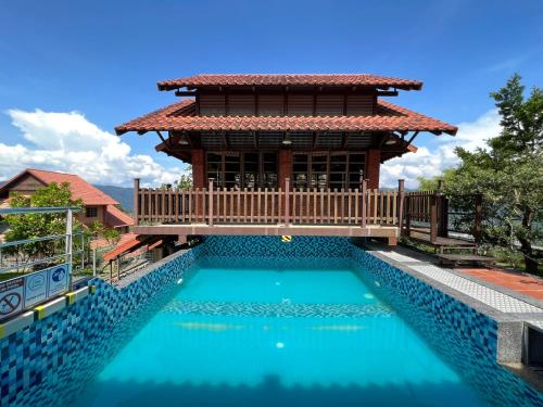 una casa con piscina di fronte a un edificio di Red House the Garden Stay in Bukit Tinggi by PLAY a Bentong