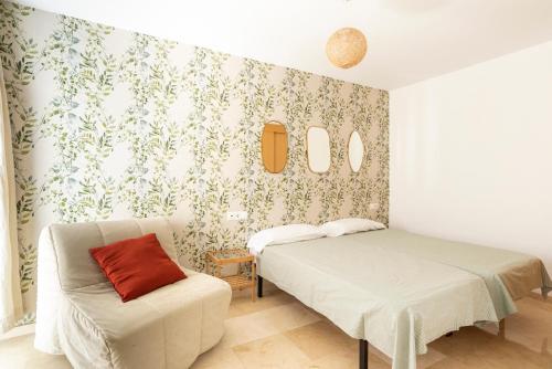 1 dormitorio con 1 cama y 1 silla en LU&CIA Victoria 3 City center, en Málaga