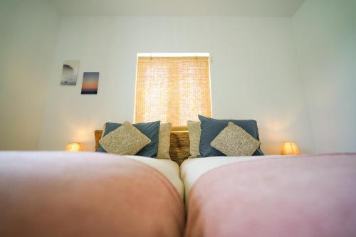 a bedroom with two beds and a window at Birds of Paradise - Boutique Surf Lodge in Aljezur