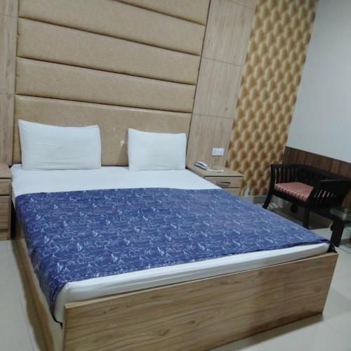 a bedroom with a bed with a blue comforter at E- Town Guest House karachi in Karachi