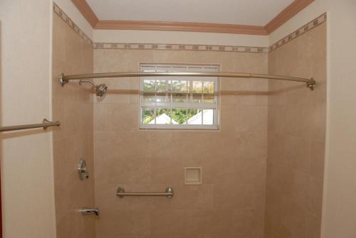 a bathroom with a shower with a window at Sandy Bliss Condominiums in Saint James