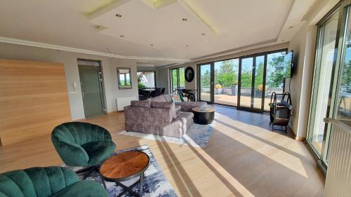 a living room with a couch and chairs and windows at Silver DeLux Apartman in Balatonfüred