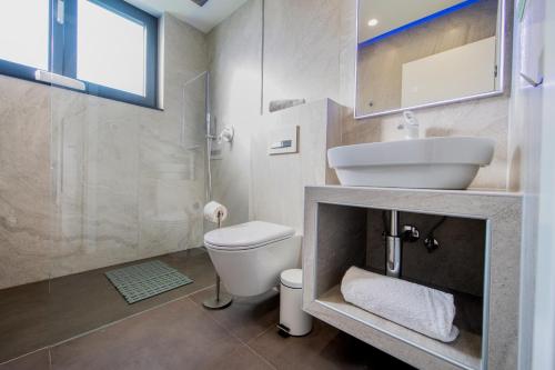 a white bathroom with a sink and a toilet at Crystal Holiday Residence in Sukošan