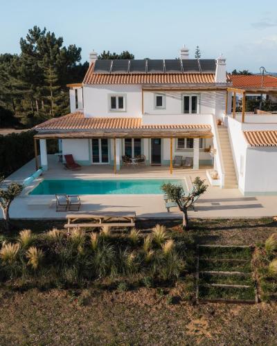 a large white house with a swimming pool at Birds of Paradise - Boutique Surf Lodge in Aljezur