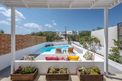an outdoor patio with a swimming pool and patio furniture at Terra Oliva Milos in Pollonia