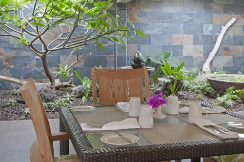 a table and chairs in a garden with a table and chairsktop at Radisson Grenada Beach Resort in Grand Anse