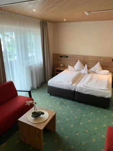 a hotel room with a bed and a red couch at Clubhotel Götzens in Innsbruck