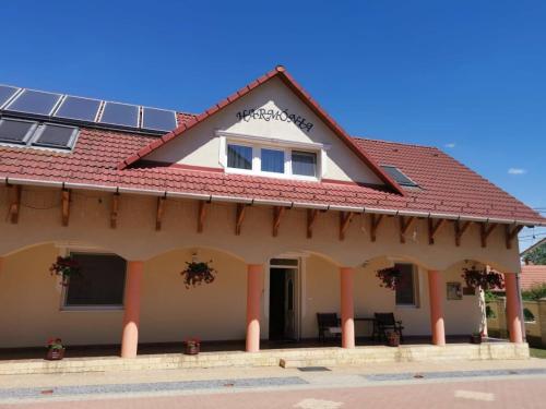 a house with a red roof with solar panels on it at Harmónia Panzió in Sárospatak
