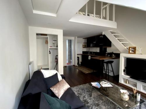 un salon avec un canapé et une table et une cuisine dans l'établissement Jolie duplex - centre historique de Vannes, à Vannes