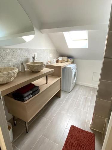 une salle de bain avec un lavabo et une machine à laver dans l'établissement Jolie duplex - centre historique de Vannes, à Vannes