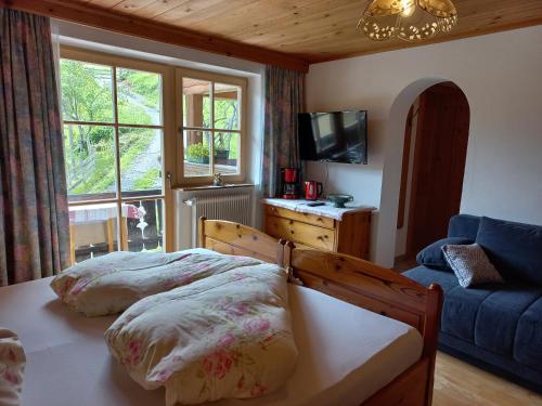 1 dormitorio con cama, sofá y ventana en Ferienzimmer Brennerbauer, en Lofer