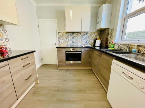 a kitchen with white cabinets and a sink at Clive Crest house in Portsmouth