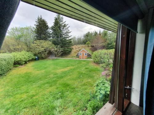 a view of a yard from a window of a house at House with a magical garden and sunroom in Höfn
