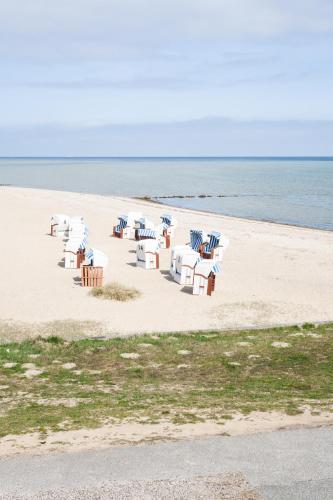 a group of tables and chairs on the beach at Bades Huk Marina Hotel in Hohen Wieschendorf