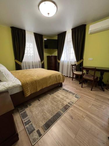a bedroom with a bed and a table and chairs at Spadok in Kamianets-Podilskyi