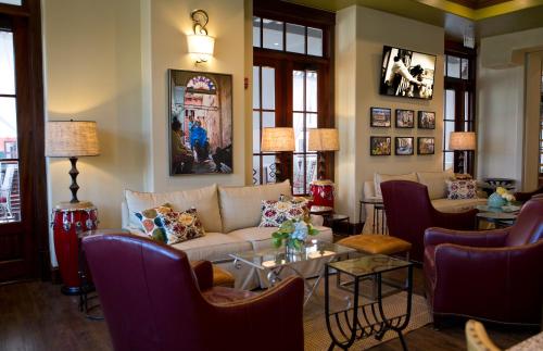 a living room with a couch and tables and chairs at The Pearl Hotel in Rosemary Beach