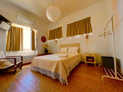a bedroom with a bed and two windows at 1955 Guest House in Cebolais de Cima