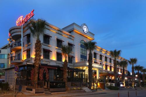 a large building with palm trees in front of it at New Balturk Hotel Izmit in Kocaeli