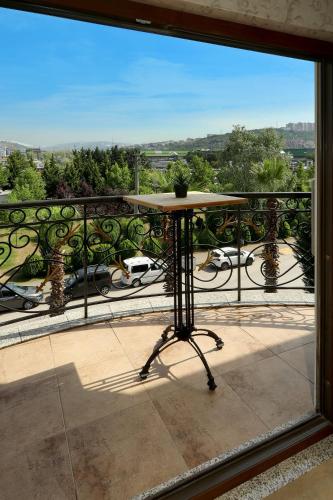 a table on a balcony with a view of a city at New Balturk Hotel Izmit in Kocaeli