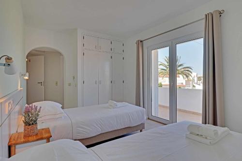 a bedroom with two beds and a large window at Villux - Vila Enar-6 quartos, ideal para familias in Albufeira