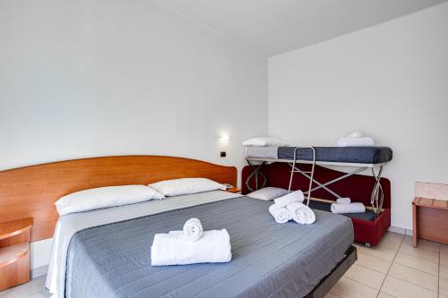 a bedroom with a bed with towels on it at HOTEL VILLA MARIA in Cesenatico