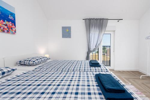 a white room with two beds and a window at Villa NiA ZadarVillas in Nin