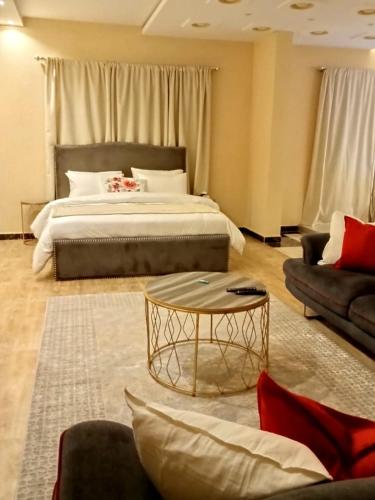 1 dormitorio con cama, mesa y sofá en شقق مفروشه خاصه بالطائف, en Taif