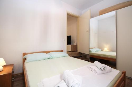 a small bedroom with two beds and a mirror at Apartment Besima 2178 in Pula
