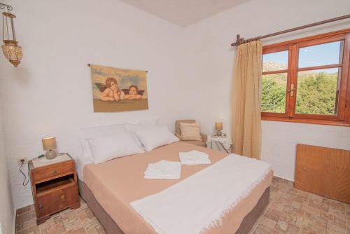 1 dormitorio con cama y ventana en Ligres Beach - 2 Bedrooms Apartment Sea View, en Agia Paraskevi